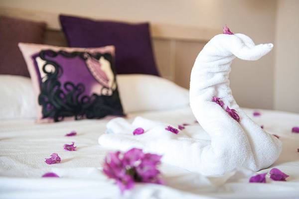Schwanenförmiges Handtuch auf einem Bett mit Blumen im Seaden Sea Planet Resort & Spa