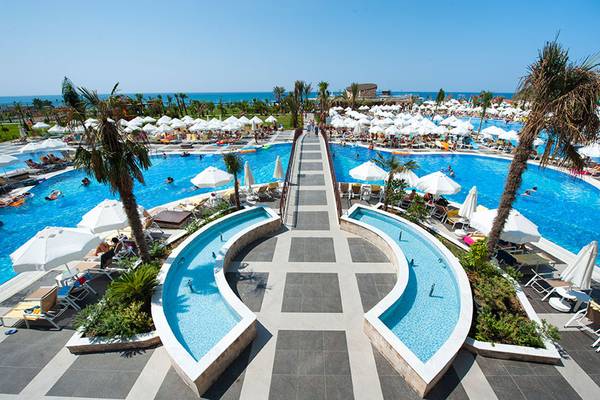 Außenbereich des Seaden Sea Planet Resort & Spa mit großen Swimmingpools, Liegestühlen und Sonnenschirmen.