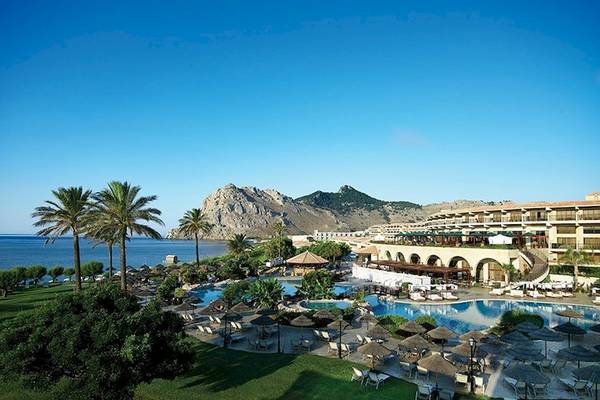 Außenansicht des Atlantica Imperial Resort & Spa mit Pool, Palmen und Berg im Hintergrund