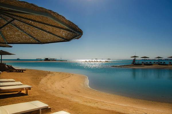 Strandszene mit Liegen, Sonnenschirmen und kristallklarem Wasser im LABRANDA Club Paradisio El Gouna
