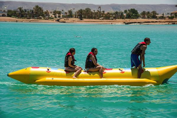 Drei Personen auf einem gelben Schlauchboot im Wasser, vor dem LABRANDA Club Paradisio El Gouna