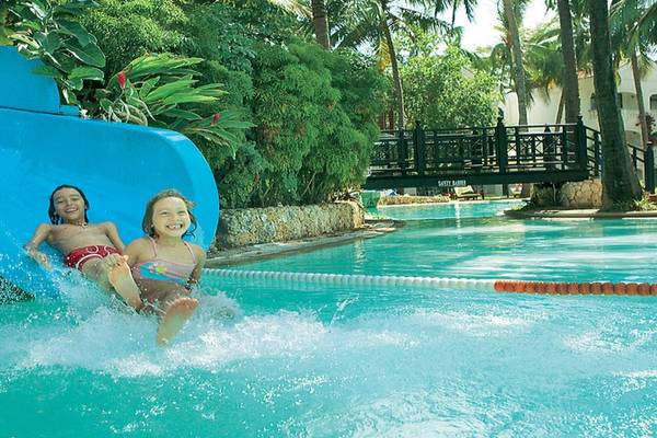 Zwei Kinder rutschen auf einer blauen Wasserrutsche im Sarova Whitesands Beach Resort & Spa.