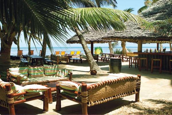 Außenbereich des Sarova Whitesands Beach Resort mit Strandliegen, Palmen und Meeresblick.