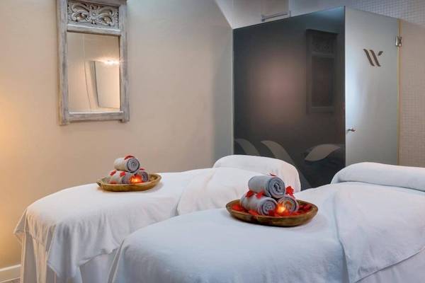 Behandlungsraum im Barcelo Corralejo Bay Hotel mit zwei Massageliegen und einem Spiegel.