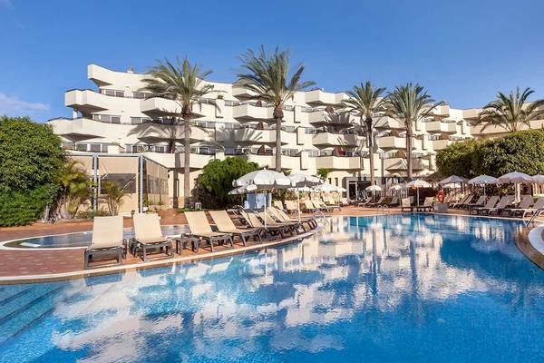 Außenpool des Barcelo Corralejo Bay Hotels mit Lounge-Stühlen und Sonnenschirmen.