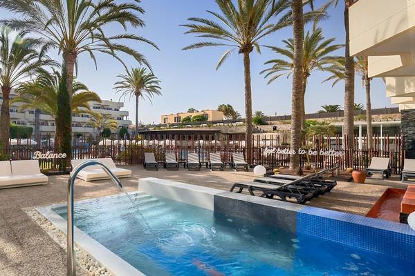 Außenpool mit Loungeliegen und Palmen im Barcelo Corralejo Bay Hotel.