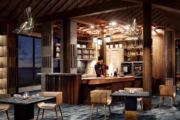 Innenansicht der Bar im JW Marriott Maldives Resort & Spa mit gedämpfter Beleuchtung und Holzelementen.
