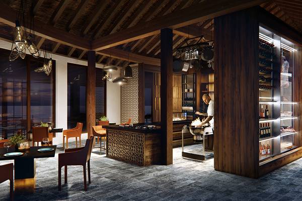 Innenbereich der Küche im JW Marriott Maldives Resort & Spa mit Holzelementen und offenem Kamin.