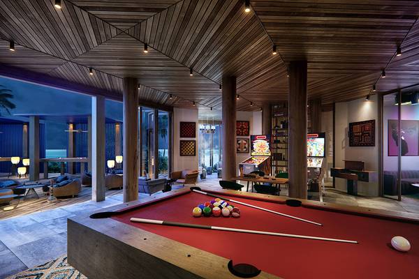 Spielzimmer im JW Marriott Maldives Resort & Spa mit Billardtisch, Sofas und Arcade-Spielen.
