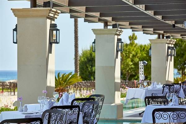 Außenbereich des Atlantica Imperial Resort & Spa mit gedeckten Tischen und Stühlen.