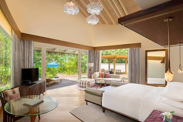 Schlafzimmer im JW Marriott Maldives Resort & Spa mit Meerblick, moderner Einrichtung und großzügigem Wohnbereich.