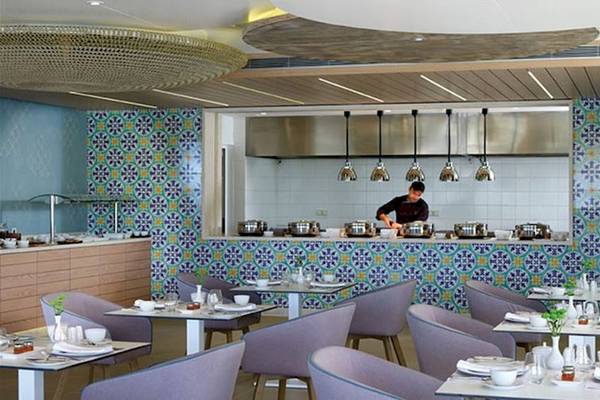 Restaurant im Atlantica Imperial Resort & Spa mit bunten Wandfliesen und einer Person, die hinter der Theke steht.