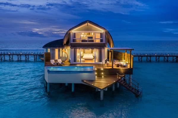 JW Marriott Maldives Resort & Spa Wasservilla mit Pool und Veranda, nachts beleuchtet