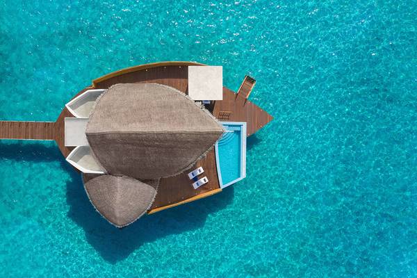 Luftaufnahme der Überwasser-Villa im JW Marriott Maldives Resort & Spa mit Pool und Sonnenliegen.
