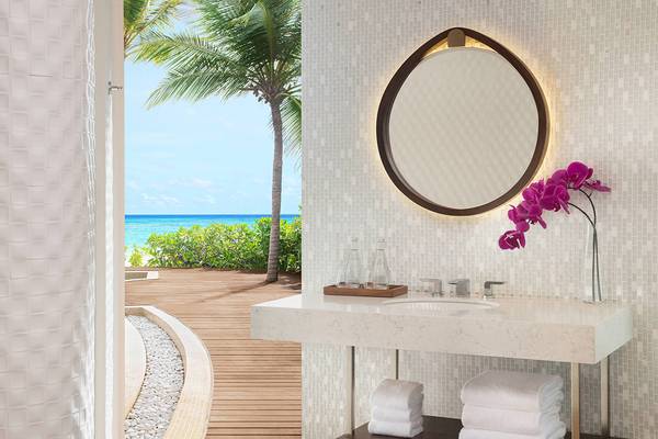 Badezimmer des JW Marriott Maldives Resort & Spa mit Aussicht auf den Ozean und Palmen