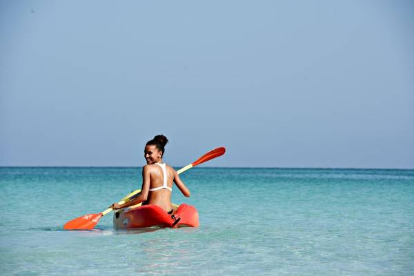 Frau im Kajak im Meer mit einem Lächeln auf dem Gesicht
