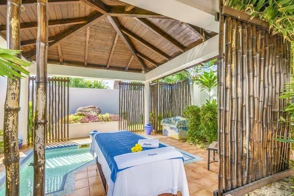 Massagebereich im Freien im Royalton Hicacos Resort & Spa mit Pool und Bambuswänden.
