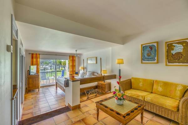 Innenansicht der Suite im Royalton Hicacos Resort & Spa mit Bett, Wohnzimmer und Balkon.