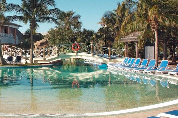 Außenpool des Royalton Hicacos Resort & Spa mit Brücke und Sonnenliegen.