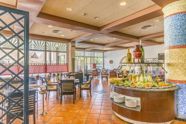 Innenansicht des Restaurants im Royalton Hicacos Resort & Spa mit Tisch, Stühlen und Speisen.