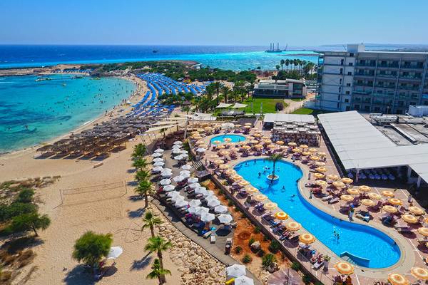 Gesamtansicht des Asterias Beach Hotels mit Strand, Pool und Gebäuden