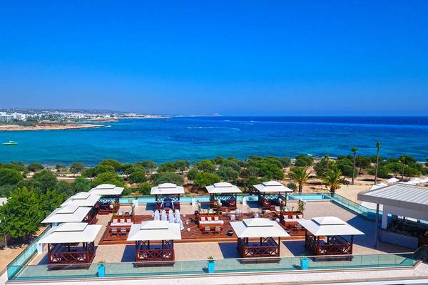 Oberirdische Terrasse des Asterias Beach Hotels mit Blick auf das Meer.