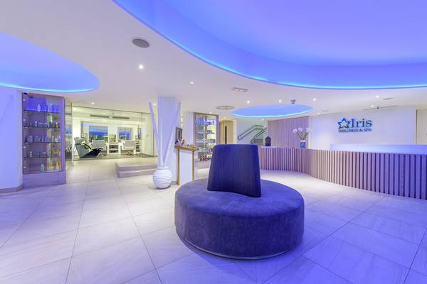 Innenansicht der Lobby des Asterias Beach Hotel mit blauer Beleuchtung und Empfangstresen.
