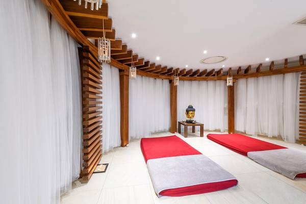 Yoga-Raum im Asterias Beach Hotel mit roten Matten und weißen Vorhängen.
