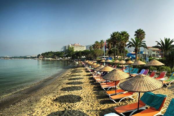Strand des Ephesia Holiday Beach Club mit vielen Liegestühlen und Sonnenschirmen.