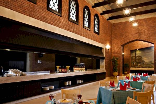Innenansicht des Restaurants im Serenity Alma Heights Hotel mit Tisch und Stühlen, Geschirr und Dekoration.