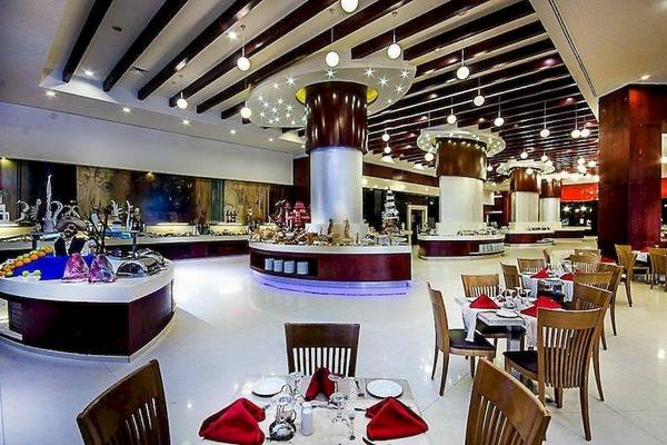 Innenansicht des Restaurants im Serenity Alma Heights Hotel mit gedeckten Tischen und Buffet.