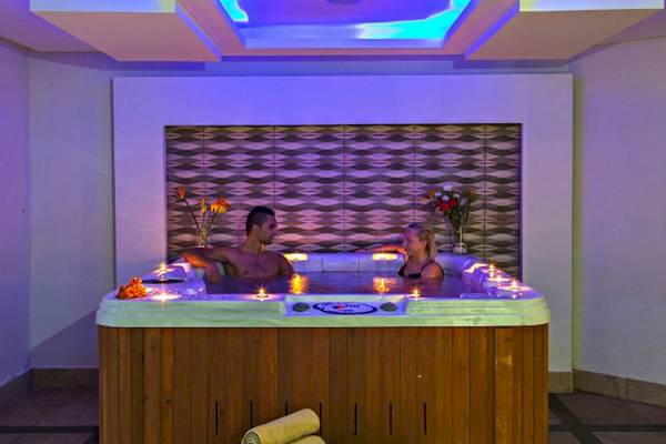 Paar in einem beleuchteten Jacuzzi im Serenity Alma Heights Hotel.
