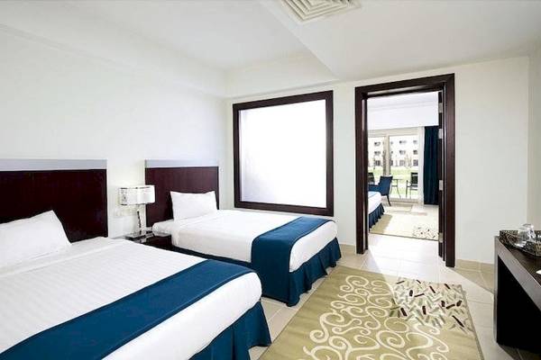 Doppelbett-Zimmer im Serenity Alma Heights Hotel mit Blick auf die Außenterrasse.