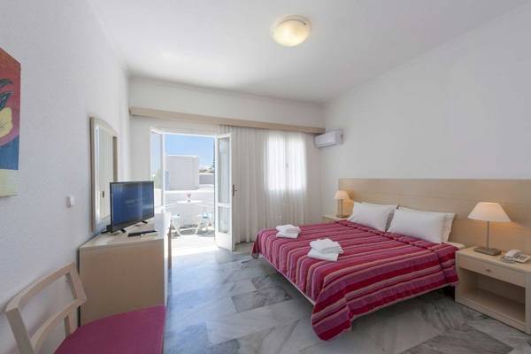 Innenansicht eines Hotelzimmers im Narges Hotel mit einem Bett, Fernseher, Tisch und Balkon.