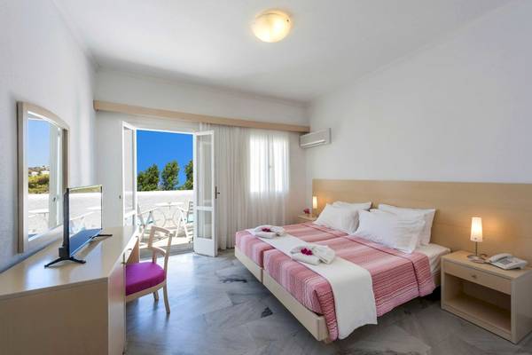 Narges Hotel Zimmer mit Balkon und Meerblick, Doppelbett, Fernseher und Schreibtisch.