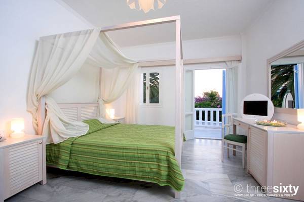 Schlafzimmer im Narges Hotel mit Baldachin, grüner Bettwäsche und Balkonzugang.