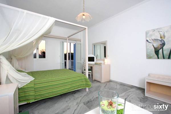 Schlafzimmer im Narges Hotel mit grünem Bett, weißem Baldachin und modernem Dekor.