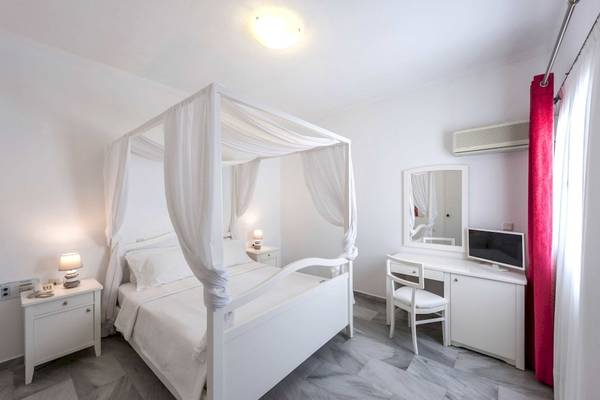 Schlafzimmer im Narges Hotel mit einem Baldachinbett, zwei Nachttischen und einem Schreibtisch.