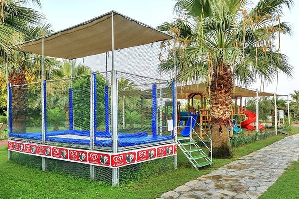 Spielplatz für Kinder im Sunis Elita Beach Resort Hotel & Spa mit Trampolin und Rutschen.