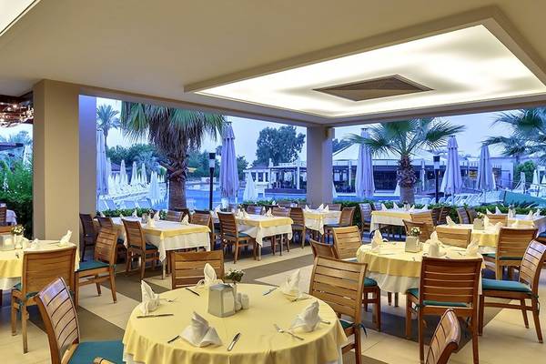 Innenansicht des Restaurants im Sunis Elita Beach Resort Hotel & Spa mit Blick auf den Pool.