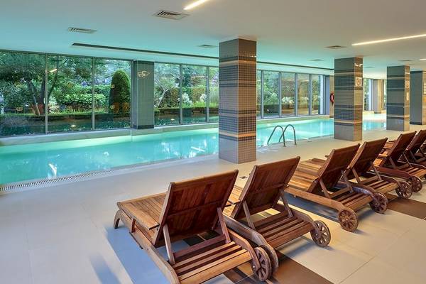 Innenpool des Sunis Elita Beach Resort Hotel & Spa mit mehreren Liegen nebeneinander
