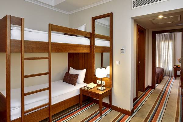 Doppelstockbett im Hotelzimmer mit Nachttisch und Lampe.