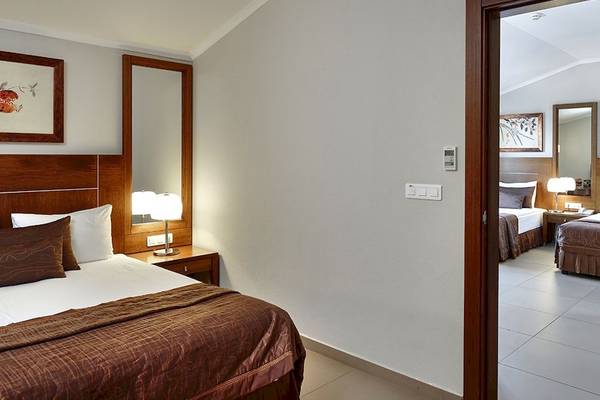Zimmer im Sunis Elita Beach Resort Hotel & Spa mit Bett, Lampen und Spiegeln.