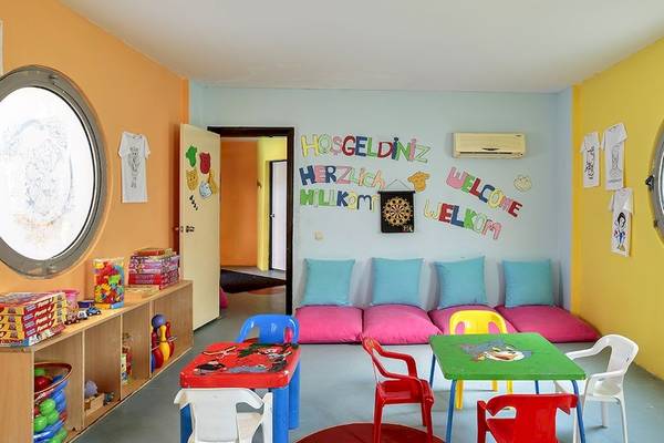 Kinder Spielzimmer im Sunis Elita Beach Resort Hotel & Spa mit bunten Wänden, Spieltischen und -stühlen.