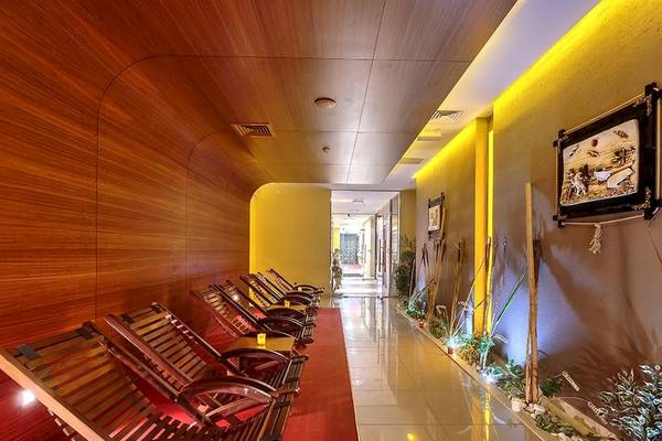 Innenbereich eines Hotels mit Holz-Loungesesseln und einem roten Teppich