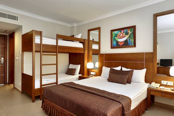 Hotelzimmer mit Doppelstockbetten und Nachttisch im Sunis Elita Beach Resort Hotel & Spa.