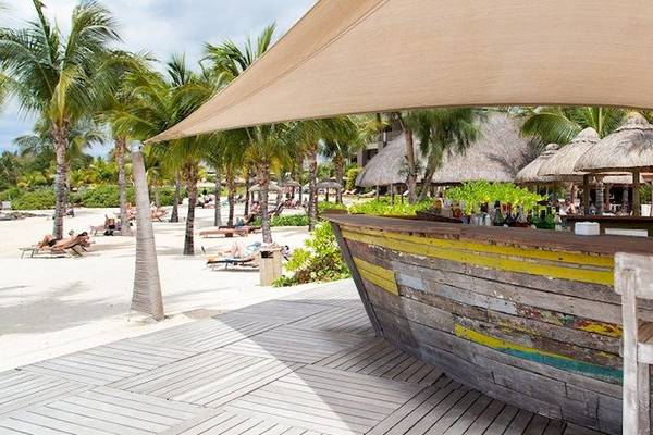 Strandbar des Zilwa Attitude Hotels mit Palmen und Sonnenschirmen im Hintergrund