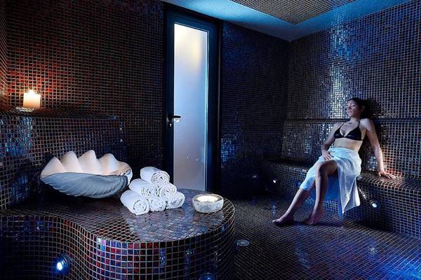 Saunaraum im Michelangelo Resort & Spa mit Frau in Badetuch
