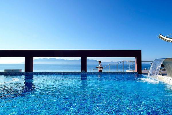 Michelangelo Resort & Spa Pool mit Blick auf das Meer und einer Person.