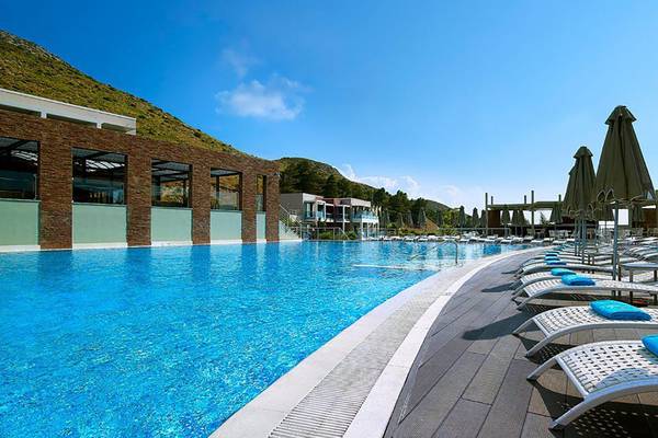 Außenpool des Michelangelo Resort & Spa mit Liegestühlen und Sonnenschirmen.